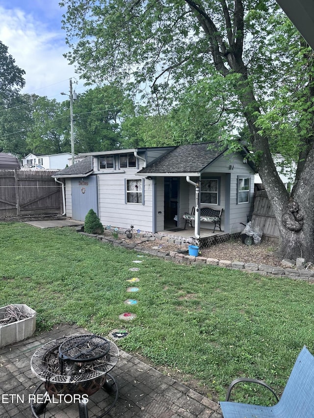 327 S Fowler St, Clinton, TN 37716 - rear view of house with fence, a shingled roof, a porch, an outdoor fire pit, and a yard