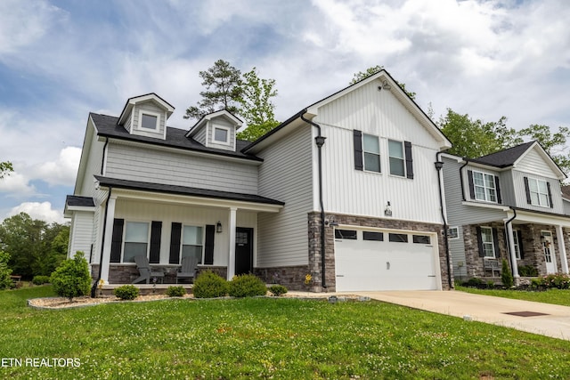 view of front facade featuring a garage, stone siding, a porch, and a front yard