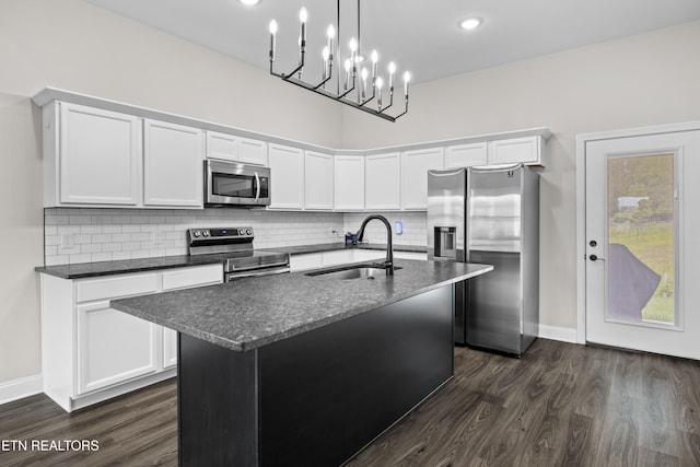 kitchen with stainless steel appliances, baseboards, dark wood finished floors, and a sink