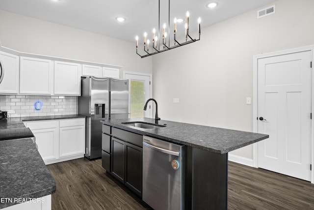 kitchen with decorative backsplash, visible vents, appliances with stainless steel finishes, a sink, and dark wood-type flooring