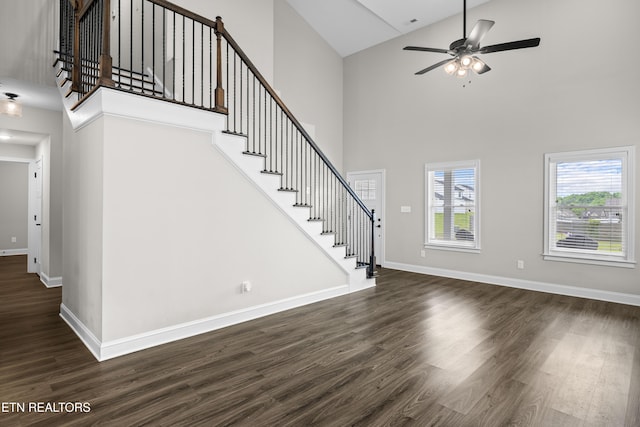 interior space featuring stairs, a ceiling fan, high vaulted ceiling, and dark wood-type flooring