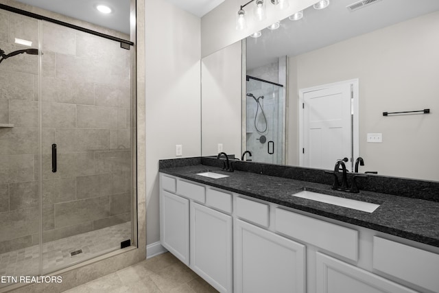 full bathroom featuring double vanity, visible vents, a sink, and a stall shower