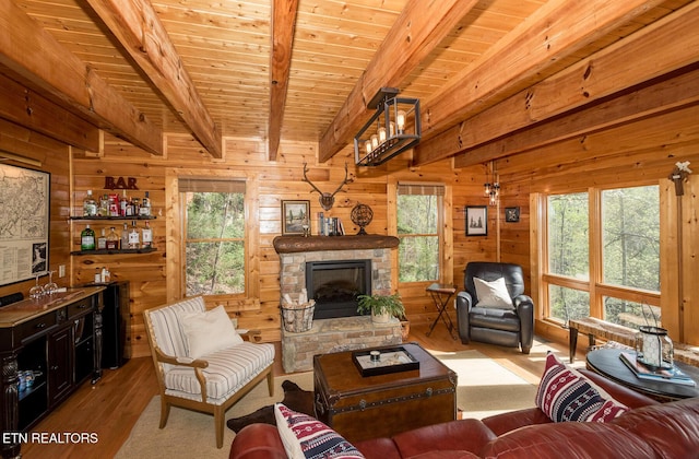 living area with beamed ceiling, wood finished floors, and plenty of natural light