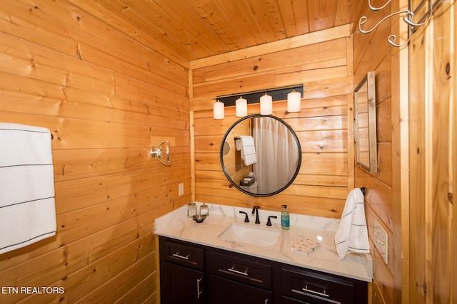 bathroom with wood ceiling, wooden walls, and vanity