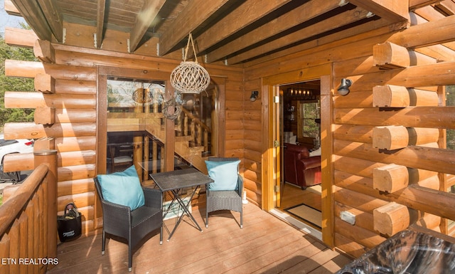 interior space with a notable chandelier, hardwood / wood-style floors, and rustic walls