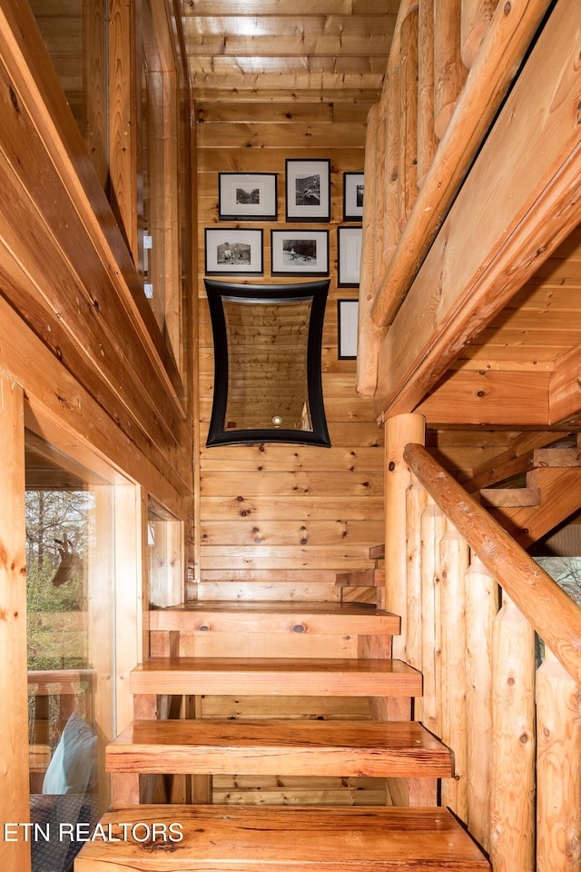 staircase featuring wooden walls and wooden ceiling