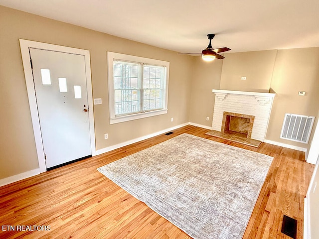 unfurnished living room featuring a ceiling fan, light wood-style floors, and visible vents