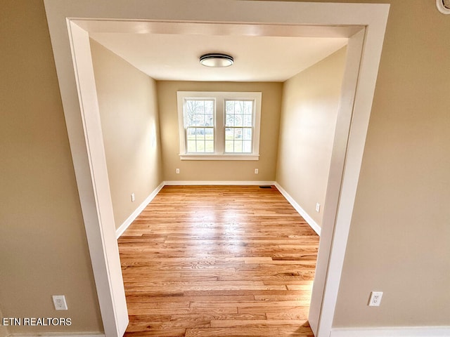 unfurnished room featuring baseboards and wood finished floors
