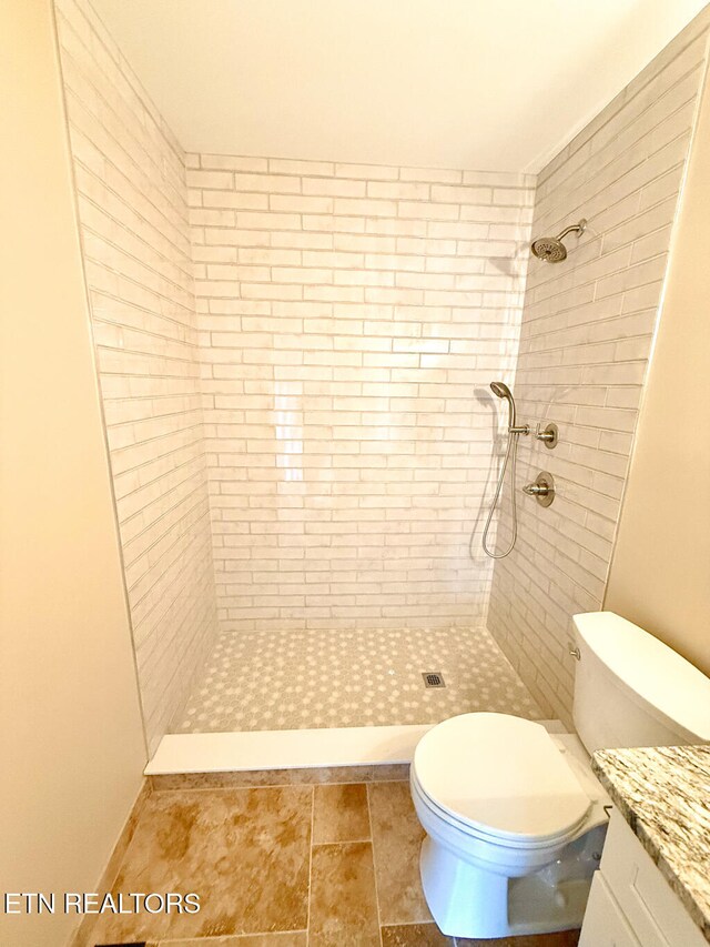 full bath with vanity, toilet, and tiled shower