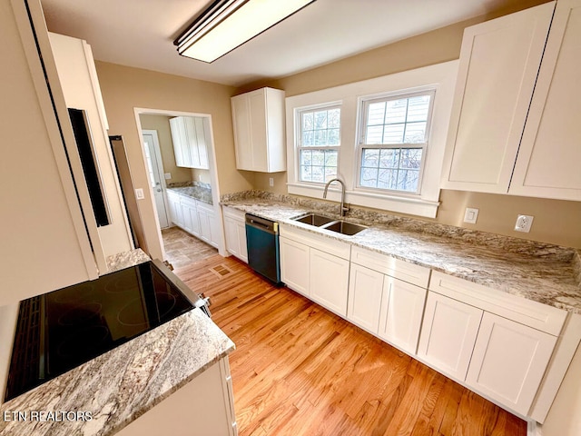 kitchen featuring white cabinets, a sink, range with electric cooktop, light wood-type flooring, and dishwashing machine