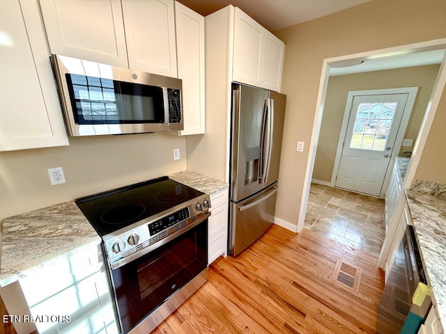 kitchen with white cabinets, visible vents, and stainless steel appliances