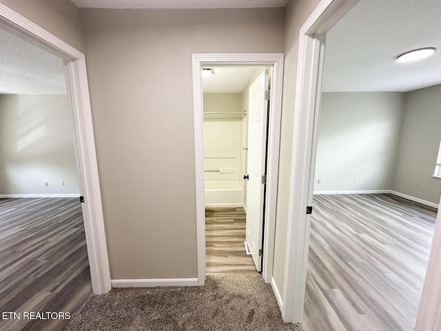 hall featuring baseboards and wood finished floors