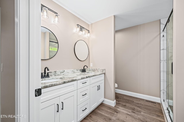 710 Westchester Dr, Crossville, TN 38558 - full bath with double vanity, wood finished floors, tiled shower, toilet, and baseboards