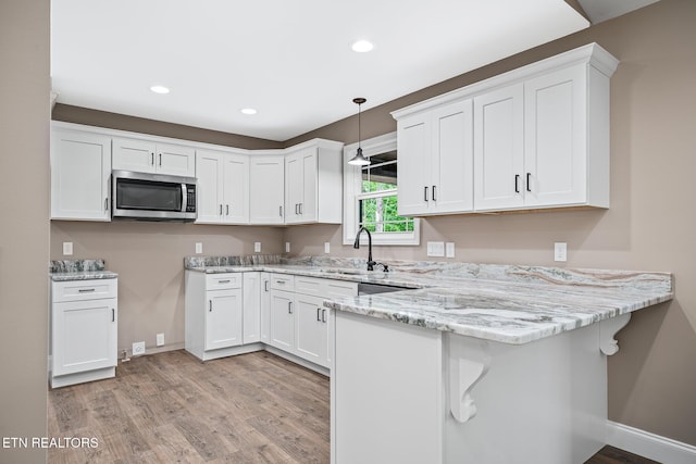 710 Westchester Dr, Crossville, TN 38558 - kitchen featuring stainless steel microwave, a sink, a peninsula, light wood-style flooring, and recessed lighting