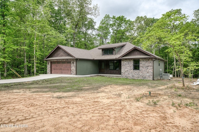 710 Westchester Dr, Crossville, TN 38558 - view of front facade with concrete driveway, an attached garage, central air condition unit, a shingled roof, and stone siding