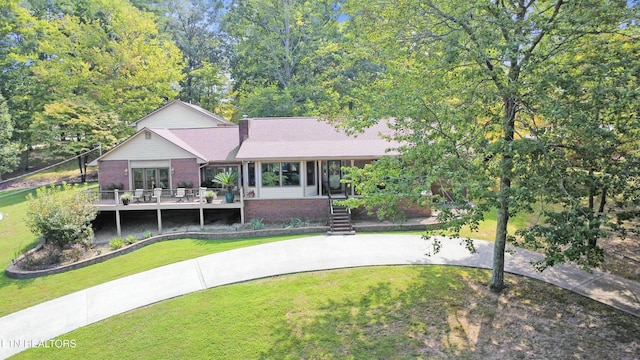 1517 Deerfield Way, Lafollette, TN 37766 - view of front of property featuring brick siding, a sunroom, a wooden deck, and a front lawn