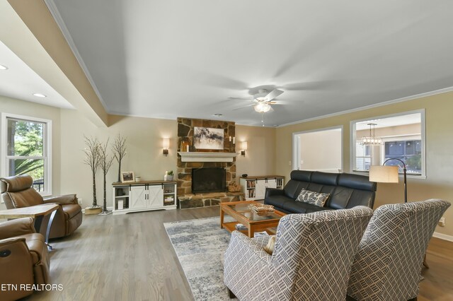 1517 Deerfield Way, Lafollette, TN 37766 - living room featuring crown molding, a stone fireplace, wood finished floors, ceiling fan with notable chandelier, and baseboards