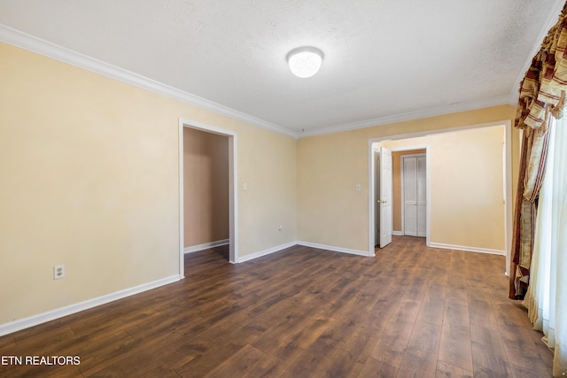 spare room featuring a textured ceiling, crown molding, baseboards, and dark wood-style flooring