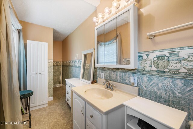 full bathroom featuring wainscoting, vanity, tile patterned flooring, and tile walls