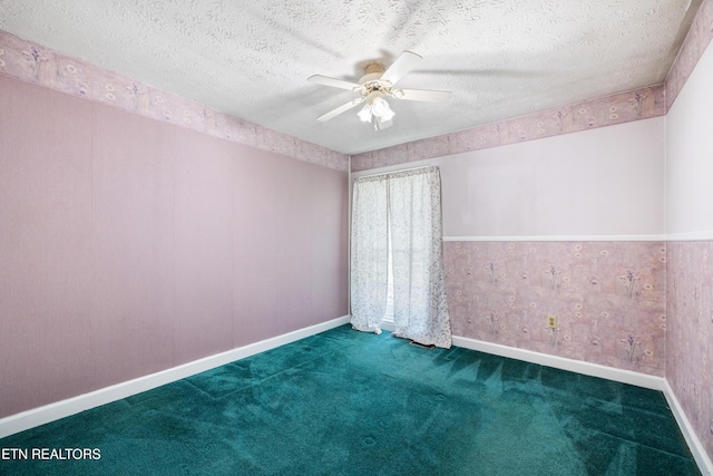 carpeted spare room with a textured ceiling, baseboards, and ceiling fan
