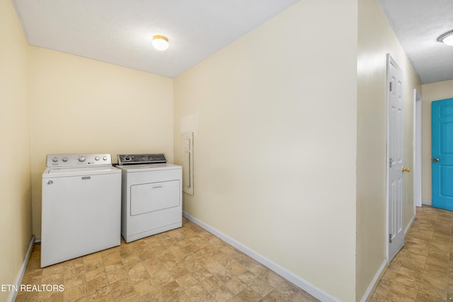 laundry area featuring baseboards, washer and clothes dryer, and laundry area