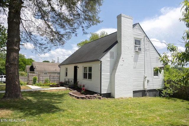rear view of property with fence, a yard, a chimney, and cooling unit