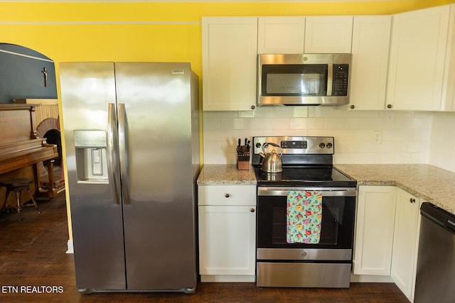 kitchen featuring light stone counters, appliances with stainless steel finishes, backsplash, and white cabinets