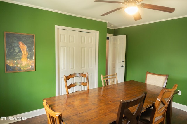 dining space with baseboards, ceiling fan, ornamental molding, and dark wood finished floors