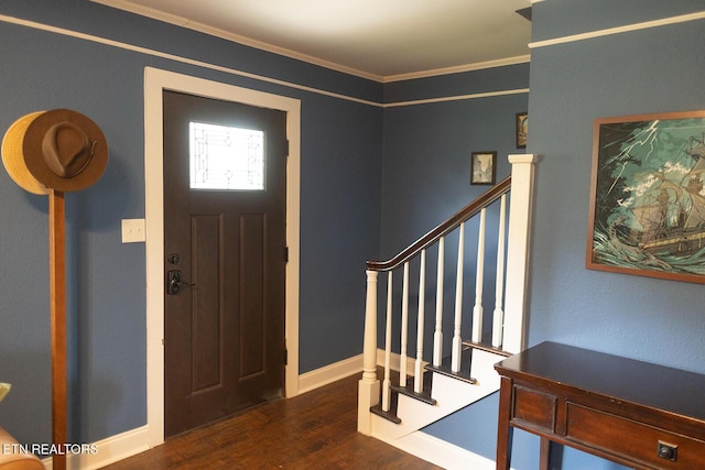 entryway featuring baseboards, ornamental molding, wood finished floors, and stairway
