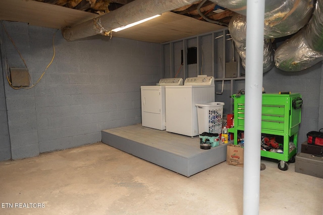 unfinished below grade area with concrete block wall and washing machine and dryer