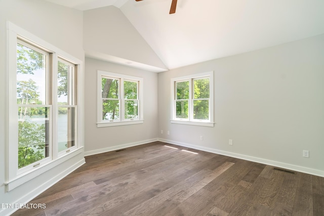 empty room with ceiling fan, vaulted ceiling, baseboards, and dark wood-type flooring