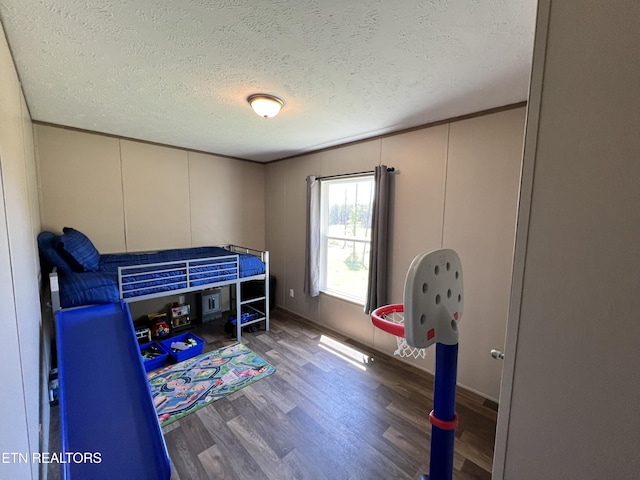 534 Wiggins Rd, Tellico Plains, TN 37385 - bedroom with a textured ceiling, wood finished floors, and a decorative wall