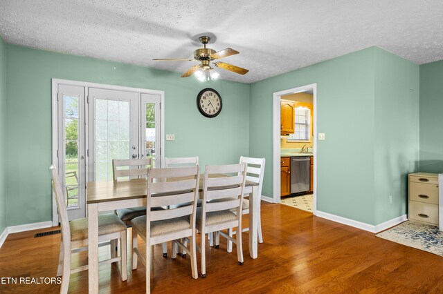 dining area with a textured ceiling, ceiling fan, wood finished floors, and baseboards