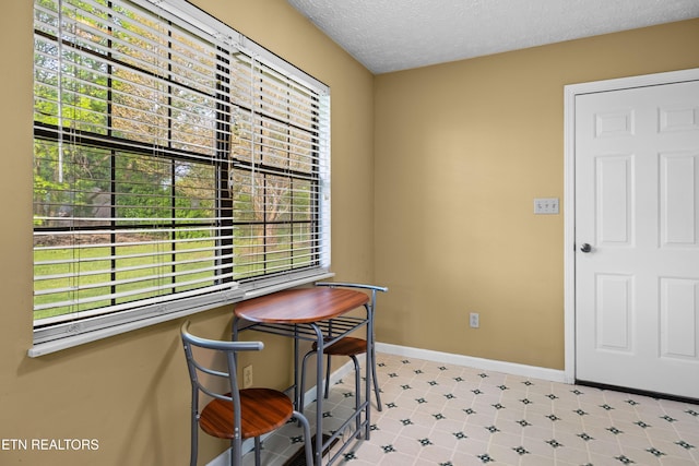 dining area with a textured ceiling and baseboards