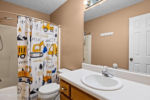 bathroom featuring toilet, a textured ceiling, shower / bath combo, and vanity