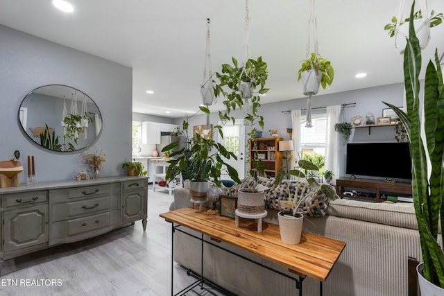 living area with light wood-type flooring, recessed lighting, and a healthy amount of sunlight