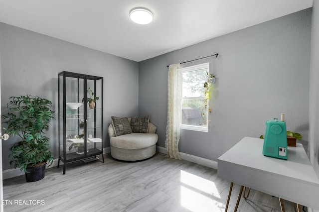 sitting room with baseboards and wood finished floors