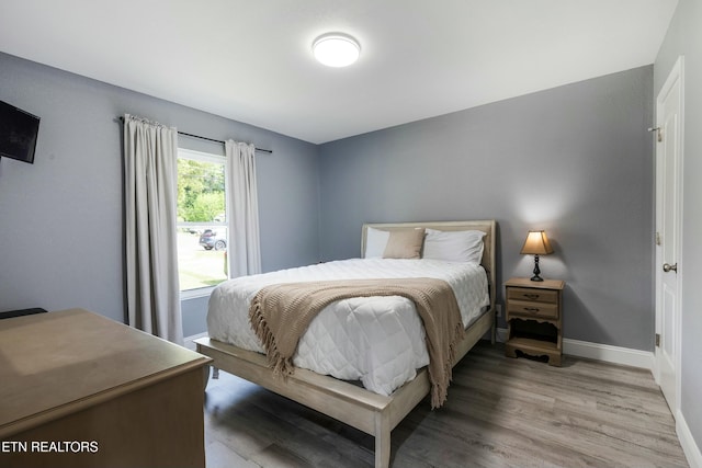 bedroom featuring light wood-style floors and baseboards