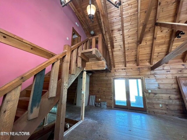 interior space with french doors, beamed ceiling, wood walls, wood ceiling, and high vaulted ceiling