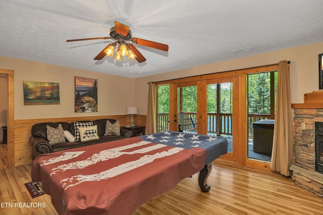 721 Poplar Falls Way, Gatlinburg, TN 37738 - bedroom with a textured ceiling, light wood-style flooring, multiple windows, and access to exterior