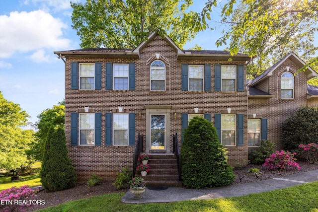 colonial home featuring brick siding