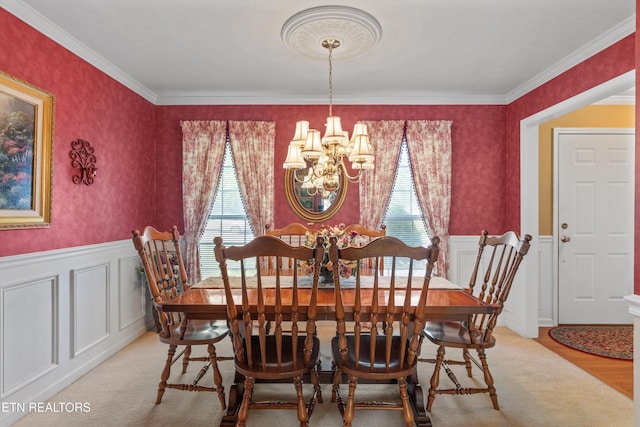 dining room featuring a notable chandelier, ornamental molding, and a wainscoted wall