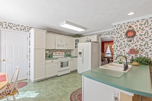 kitchen with crown molding, a sink, light floors, wallpapered walls, and white appliances
