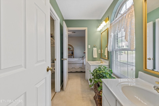 bathroom with a sink, connected bathroom, and two vanities