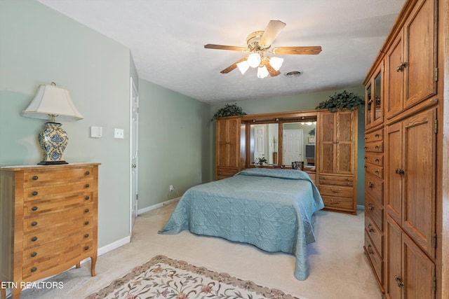 bedroom featuring baseboards, visible vents, light carpet, and ceiling fan