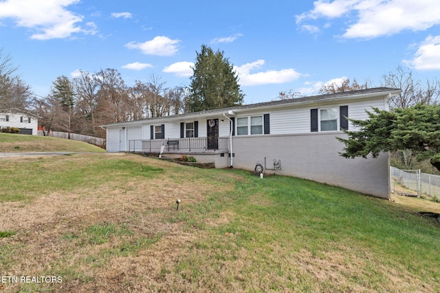 ranch-style home featuring fence, brick siding, and a front yard