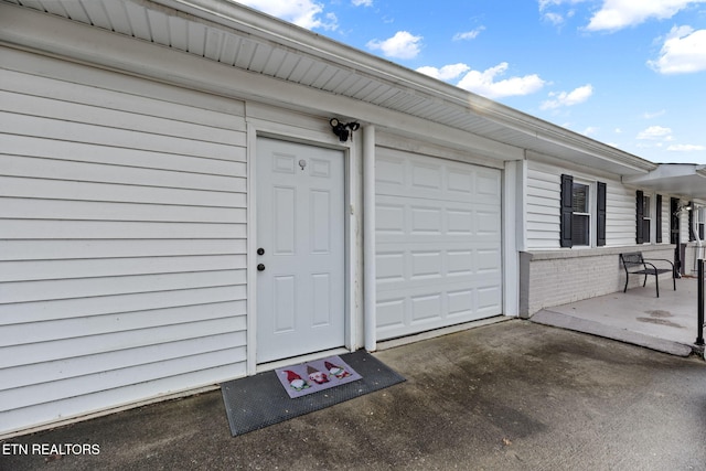 entrance to property featuring driveway and a garage