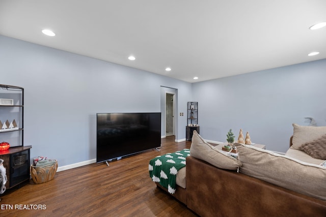 living area featuring baseboards, wood finished floors, and recessed lighting