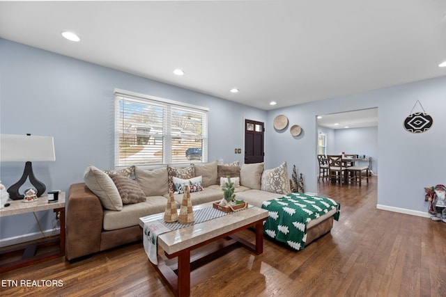 living area with baseboards, wood finished floors, and recessed lighting