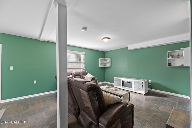living area with baseboards and stone tile flooring